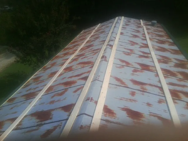 Rusted metal roof panels with new wood purlins before replacement — Storm Damage Roof Repair in Kinsman by Roofing Brothers