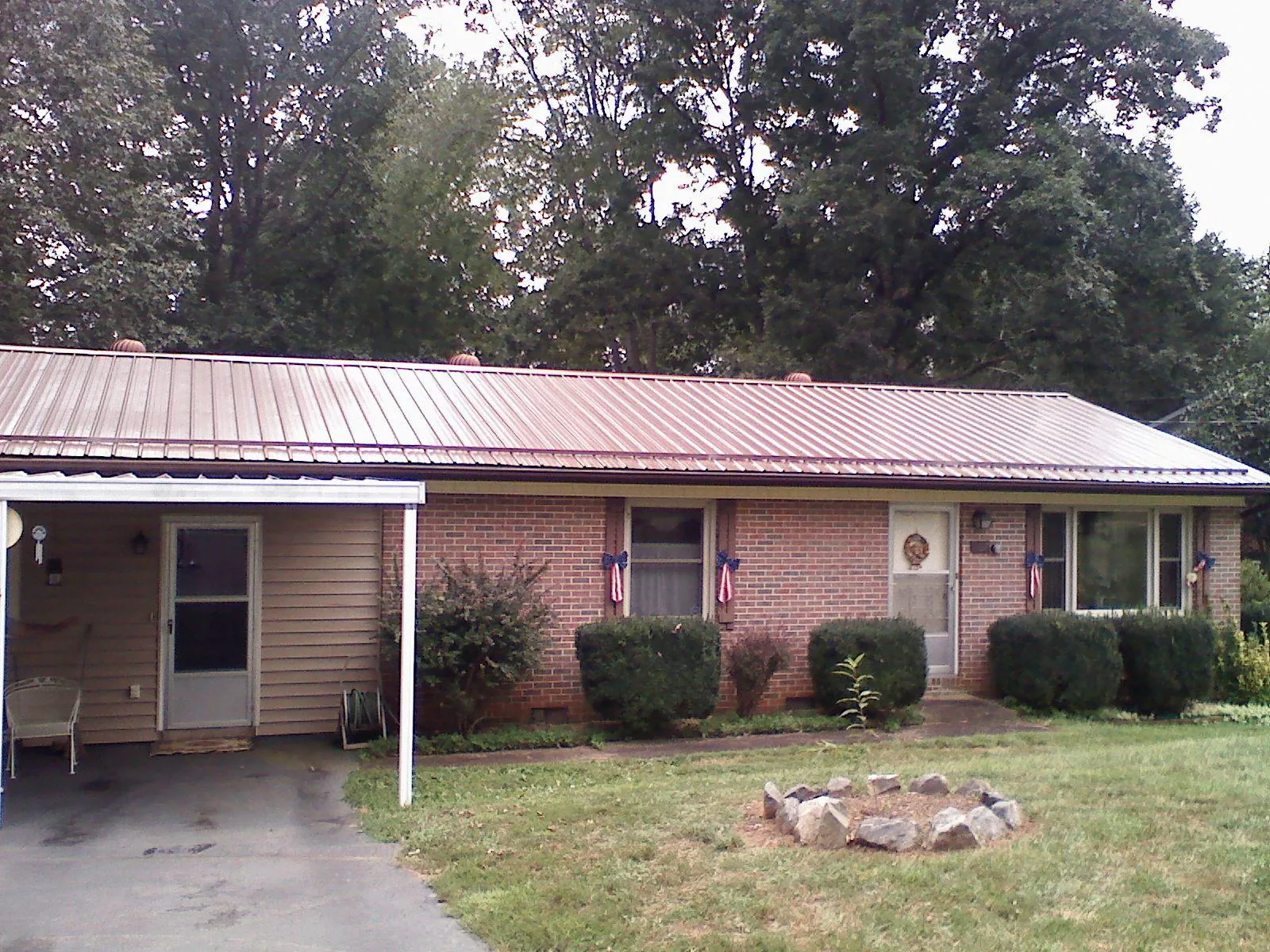 Bronze metal roof and carport on a brick ranch home — Roof Repair work by our crew in Kinsman